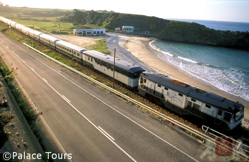 Costa Verde luxury train traveling along coastal railway beside pristine beach and ocean